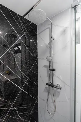 a shower with a black and white tiled wall at Casa do Paulinhos - Vista Panorâmica, Natureza, Wi-Fi Rápido in Estreito da Calheta