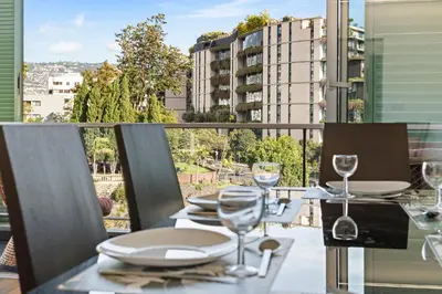 a table with plates and wine glasses on a balcony at Vista Savoy Apartamento in Funchal