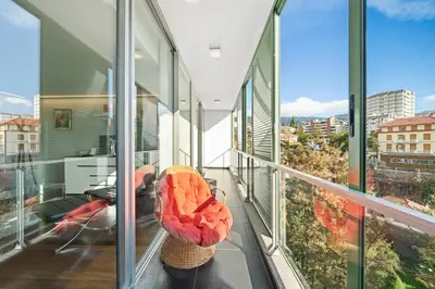 a room with glass walls and a balcony at Vista Savoy Apartamento in Funchal