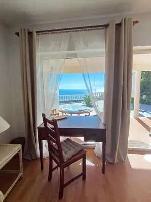 a dining room with a table and a view of the ocean at Private Oceanfront Cottage with 180 degree Sea View, 100 m Terrace in Funchal