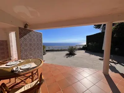 a patio with a table and chairs and the ocean at Private Oceanfront Cottage with 180 degree Sea View, 100 m Terrace in Funchal
