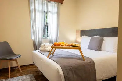 a bedroom with a bed with a tray of fruit on it at Til s Place in São Vicente