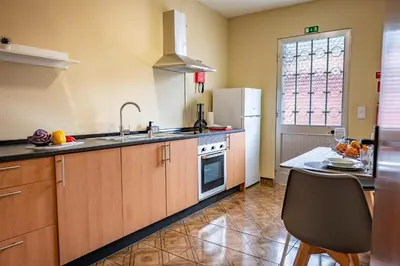 a kitchen with a sink and a refrigerator at Til s Place in São Vicente