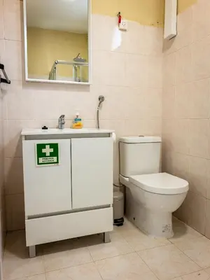 a bathroom with a toilet and a sink and a mirror at Til s Place in São Vicente
