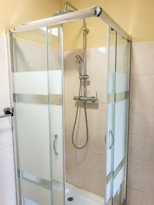 a shower with a glass door in a bathroom at Til s Place in São Vicente
