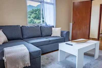 a living room with a blue couch and a white table at Til s Place in São Vicente