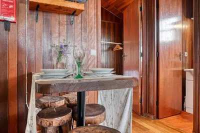 a kitchen with a bar with stools and wine glasses at Chalet do Relógio d'Água, a Home in Madeira in Ponta do Sol