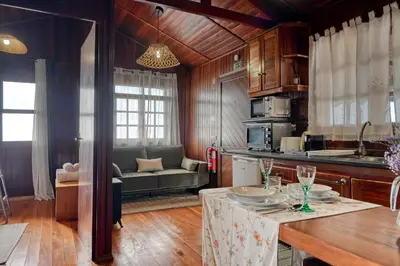 a kitchen and living room with a table and a couch at Chalet do Relógio d'Água, a Home in Madeira in Ponta do Sol