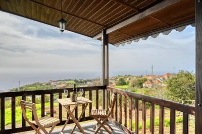 a balcony with a table and chairs and a view at Chalet do Relógio d'Água, a Home in Madeira in Ponta do Sol