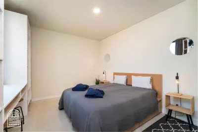 a bedroom with a large bed with blue towels on it at Good Times Sagres in Sagres
