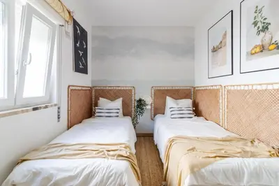 two beds in a room with white walls and a window at Casa Phoebe - NEW Renovated Burgau Apartment Sleeps 5 - Beach 1 min in Burgau