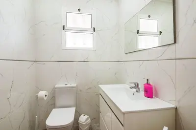 a bathroom with a sink and a toilet and a mirror at Villa do Carmo by GALMI in Funchal