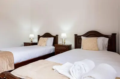 two beds with towels on them in a bedroom at Villa do Carmo by GALMI in Funchal
