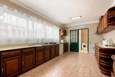 a large kitchen with wooden cabinets and a large window at Villa do Carmo by GALMI in Funchal