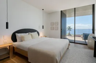 a bedroom with a bed and a view of the ocean at Savoy Monumentalis VII by An Island Apart in Funchal