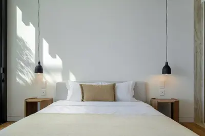 a bedroom with a white bed with two night stands at Savoy Monumentalis VII by An Island Apart in Funchal