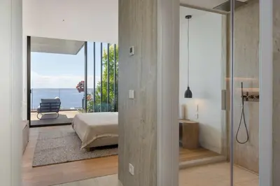 a bedroom with a bed and a view of the ocean at Savoy Monumentalis VII by An Island Apart in Funchal