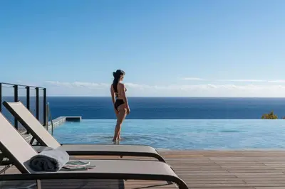 a woman in a bikini standing in a swimming pool at Savoy Monumentalis VII by An Island Apart in Funchal