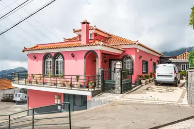 a pink house with a balcony in a parking lot at Ocean Hill View By Zest&Guest in Câmara de Lobos