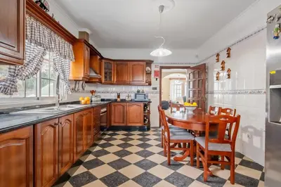 a kitchen with wooden cabinets and a table and chairs at Ocean Hill View By Zest&Guest in Câmara de Lobos