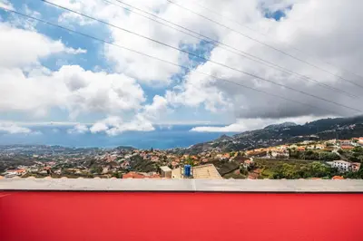 a view of a city from a red wall at Ocean Hill View By Zest&Guest in Câmara de Lobos