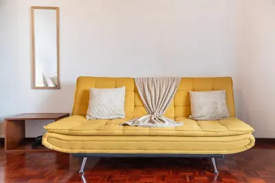 a yellow couch sitting in a living room at João Loft II by Mth in Campanário