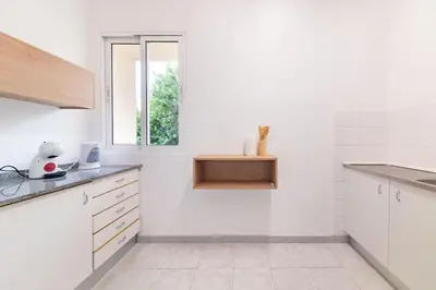 a white kitchen with white cabinets and a window at João Loft II by Mth in Campanário