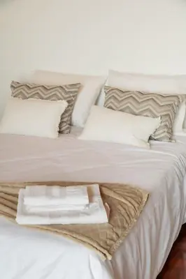a white bed with a pile of towels on it at João Loft II by Mth in Campanário
