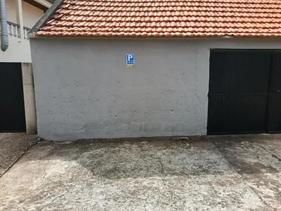a parking sign on a wall with a parking symbol at Adelaide's Cottage in Ponta do Pargo