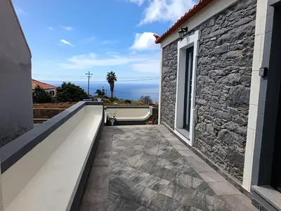 a white wall in a alley between two buildings at Adelaide's Cottage in Ponta do Pargo