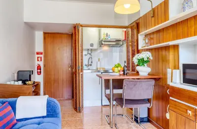 a living room with a table and a kitchen at Aida's Place, a Home in Madeira in Funchal