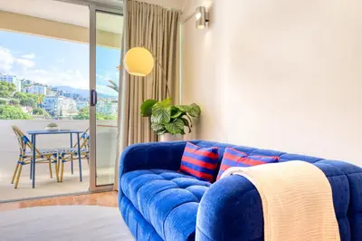 a blue couch in a living room with a table at Aida's Place, a Home in Madeira in Funchal