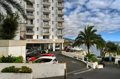 a parking lot with cars parked in front of a building at Aida's Place, a Home in Madeira in Funchal