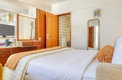 a bedroom with a bed and a tv and a chair at Aida's Place, a Home in Madeira in Funchal