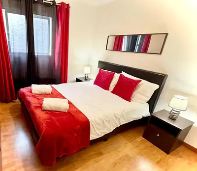 a bedroom with a large bed with red pillows at Serenity - Relax, Unwind & Feel at Home in Estreito da Calheta