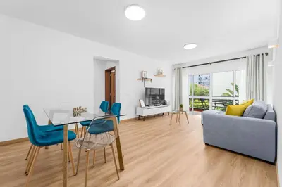 a dining room with a glass table and blue chairs at Orion's Retreat Garajau, Caniço in Caniço