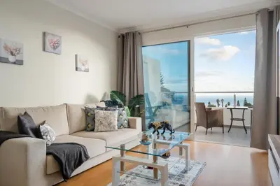 a living room with a couch and a glass table at Sunflower Stay by Homie in Caniço