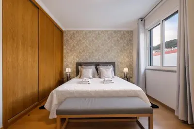 a bedroom with a large bed and a window at Sunflower Stay by Homie in Caniço