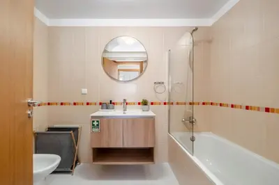 a bathroom with a sink and a tub and a mirror at Sunflower Stay by Homie in Caniço
