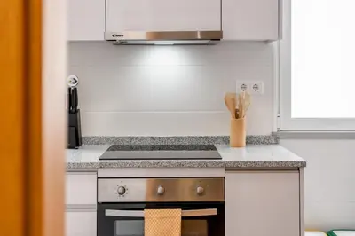a kitchen with a stove and a microwave at Sunflower Stay by Homie in Caniço