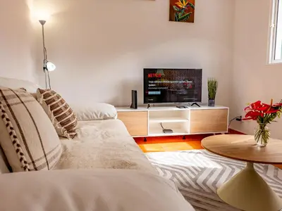 a living room with a couch and a flat screen tv at Vista do Vale, By OP in São Vicente