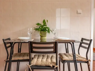 a dining room table with two chairs and a plant at Vista do Vale, By OP in São Vicente