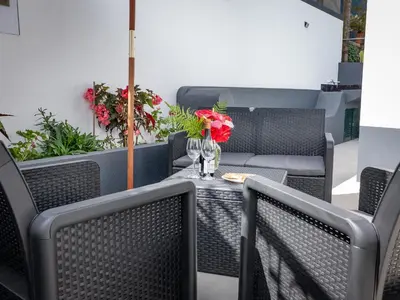 a table with glasses and flowers on a patio at Vista do Vale, By OP in São Vicente