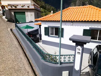 a white house with a balcony with an umbrella at Vista do Vale, By OP in São Vicente