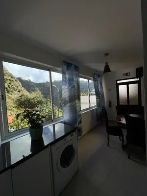 a living room with a washing machine and a window at Casinha da Montanha - Paraíso 7 in Ribeira Brava