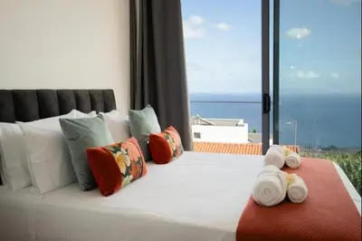 a bedroom with a bed with a view of the ocean at Figueira House in Santa Cruz