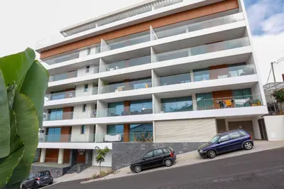 two cars parked in front of a building at Luxury LeilaMar Apartment - Modern Retreat in Funchal