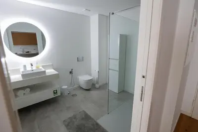 a white bathroom with a sink and a mirror at Luxury LeilaMar Apartment - Modern Retreat in Funchal