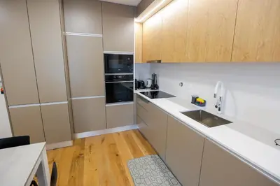a kitchen with white cabinets and a sink at Luxury LeilaMar Apartment - Modern Retreat in Funchal