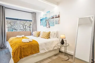a bedroom with a bed with a yellow blanket at Funchal City Marina Apartment in Funchal